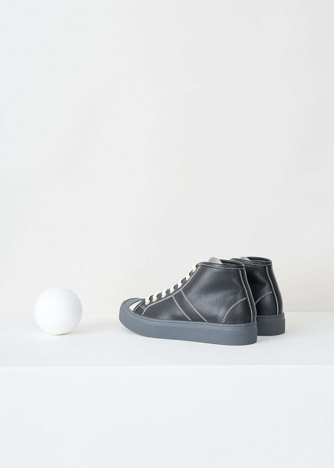 Sofie d'Hoore, Foster sneakers in black/grey, AW22_FOSTER_LCHAR_BLACK, Black, Grey, Back, These black Foster sneakers feature a front lace-up closure with matching black laces. The tongue is light grey, and white stitching is used throughout. They have a round toe with a dark grey rubber toe cap and dark grey rubber soles.
