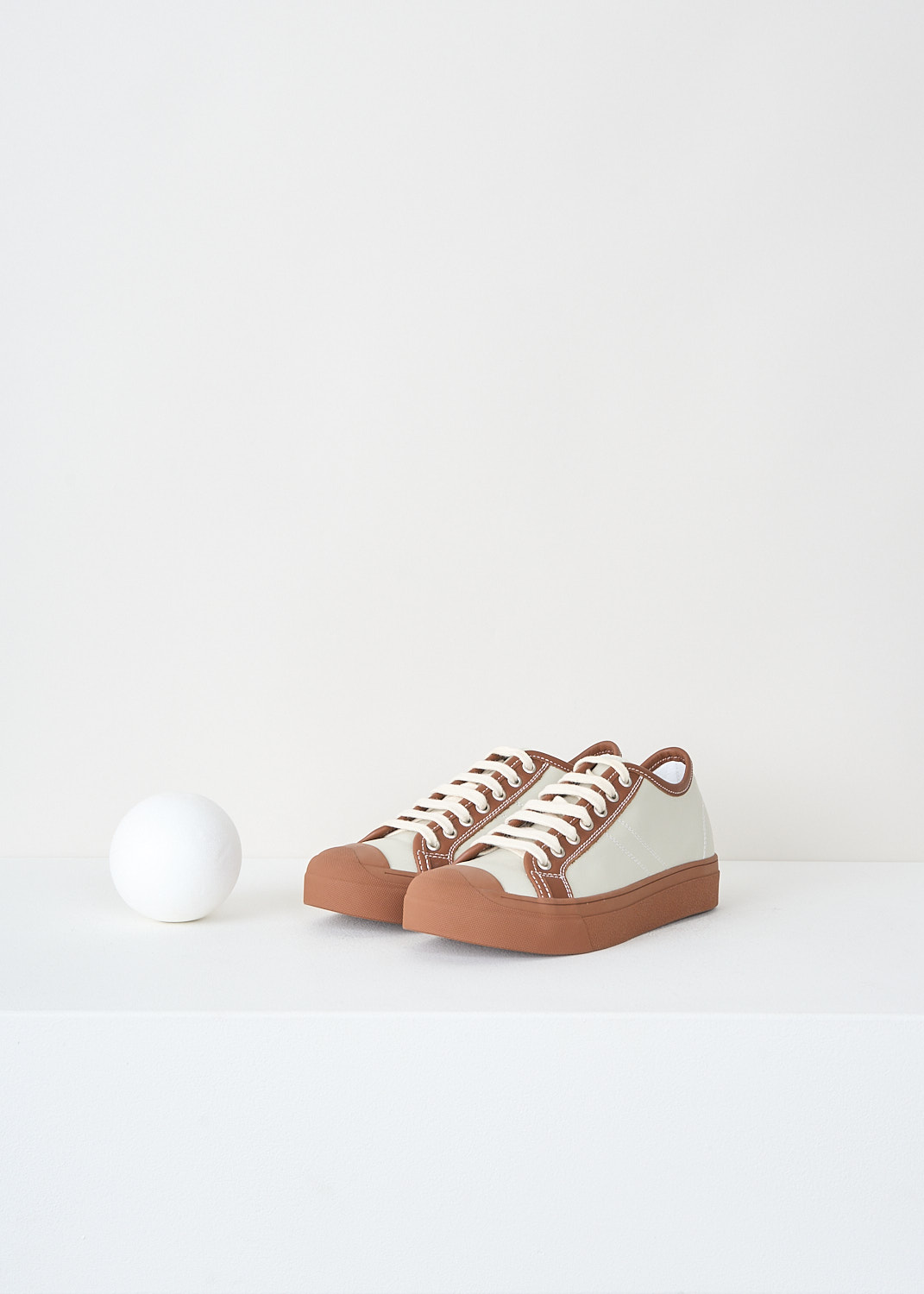 Close-up detail of Sofie D’Hoore grey Falco sneakers showing brown eyelet detailing and brown topline finish