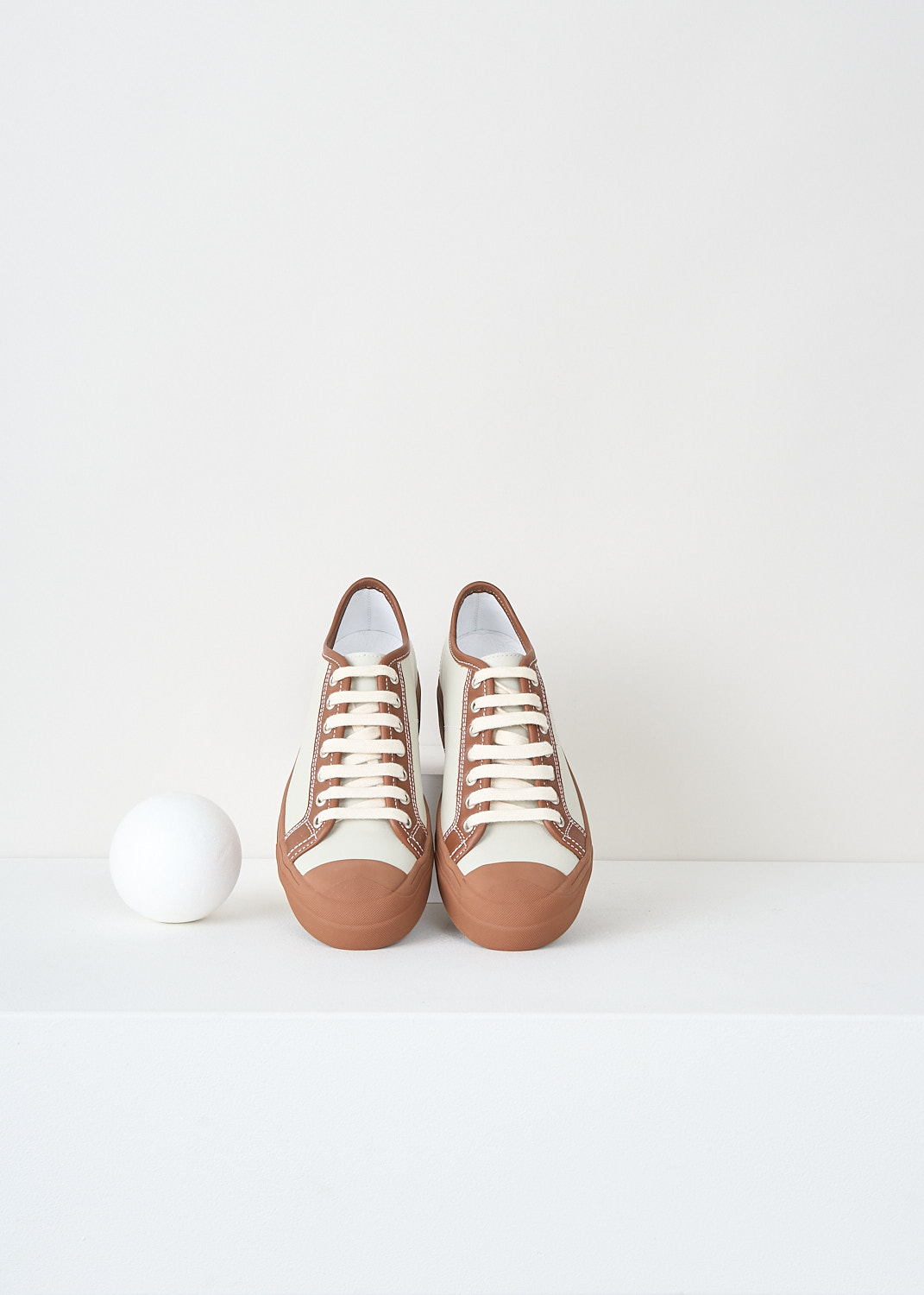Close-up detail of Sofie D’Hoore grey Falco sneakers showing brown eyelet detailing and brown topline finish