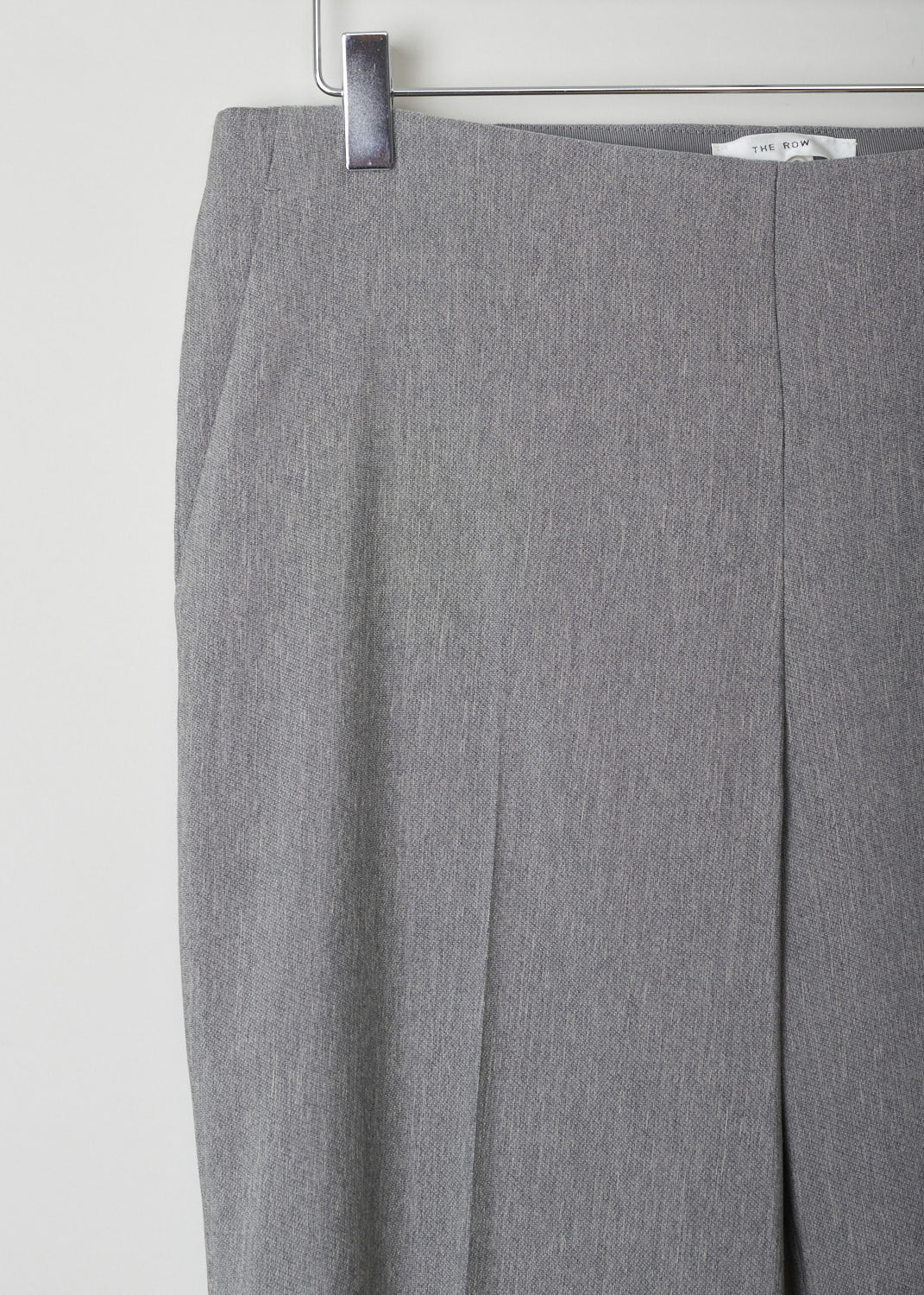 The Row, Heather grey pants without waistband, Ladan_pant_4775WI_030_MDM_GRY_MLNGE, Grey, Detail, Heather grey straight-fitted pants without waistband. These pants have slanted pockets on either side and an invisible zipper fastening on the side. In the front and back, along the length of the legs, centre creases can be found.

