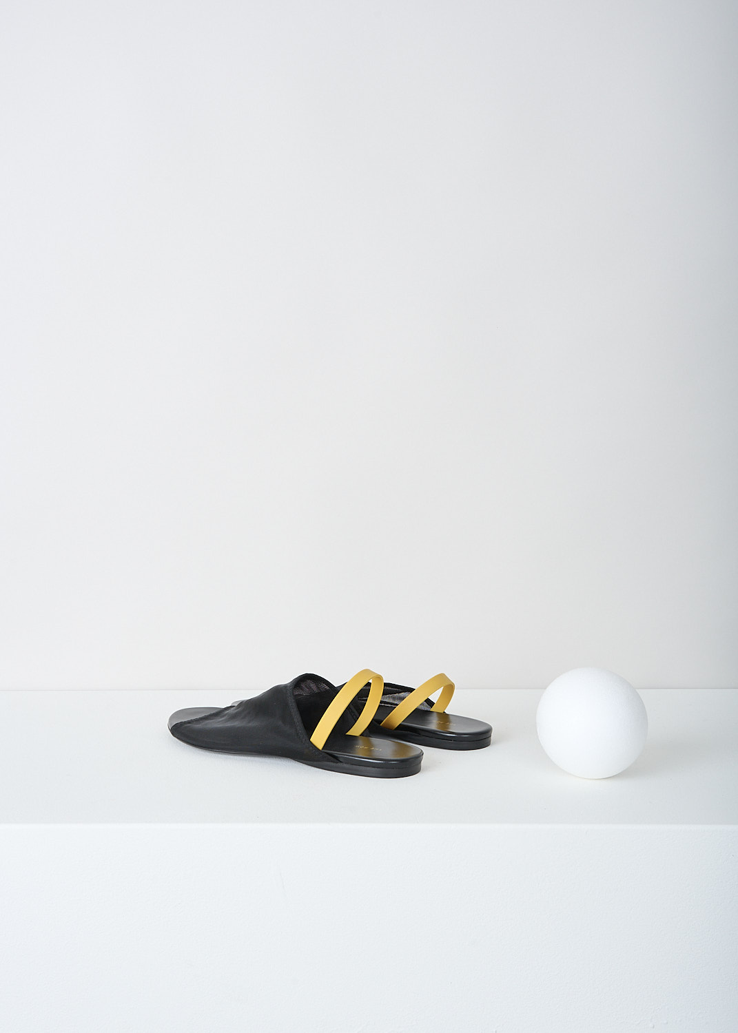 The Row, Black slingback sandal with yellow strap, CLEAR_SANDAL_F1164_W20_BLACK, Black, Yellow, Back, These black slingback sandals have a broad strap across the vamp and a round open toe. On the heel, these sandals have a slim contrasting yellow strap.
