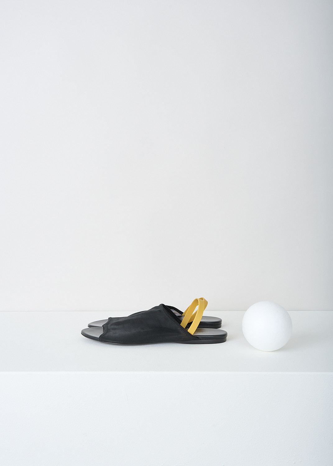 The Row, Black slingback sandal with yellow strap, CLEAR_SANDAL_F1164_W20_BLACK, Black, Yellow, Side, These black slingback sandals have a broad strap across the vamp and a round open toe. On the heel, these sandals have a slim contrasting yellow strap.

