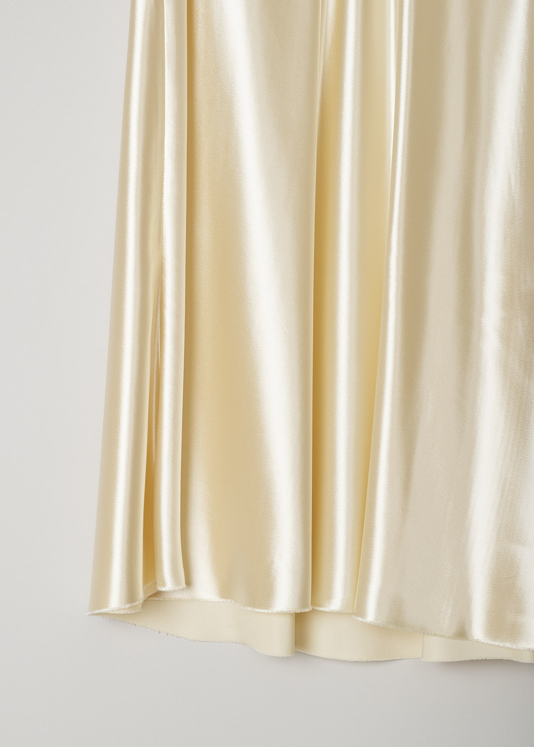 THE ROW, SATIN MEDELA SKIRT IN VANILLA, MEDELA_SKIRT_I068WI_723_VANILLA, Beige, White, Detail, This flared vanilla yellow satin skirt has an elasticated waistband and a concealed side zip that functions as the closure option. The skirt has an asymmetrical hemline with a raw finish. 

