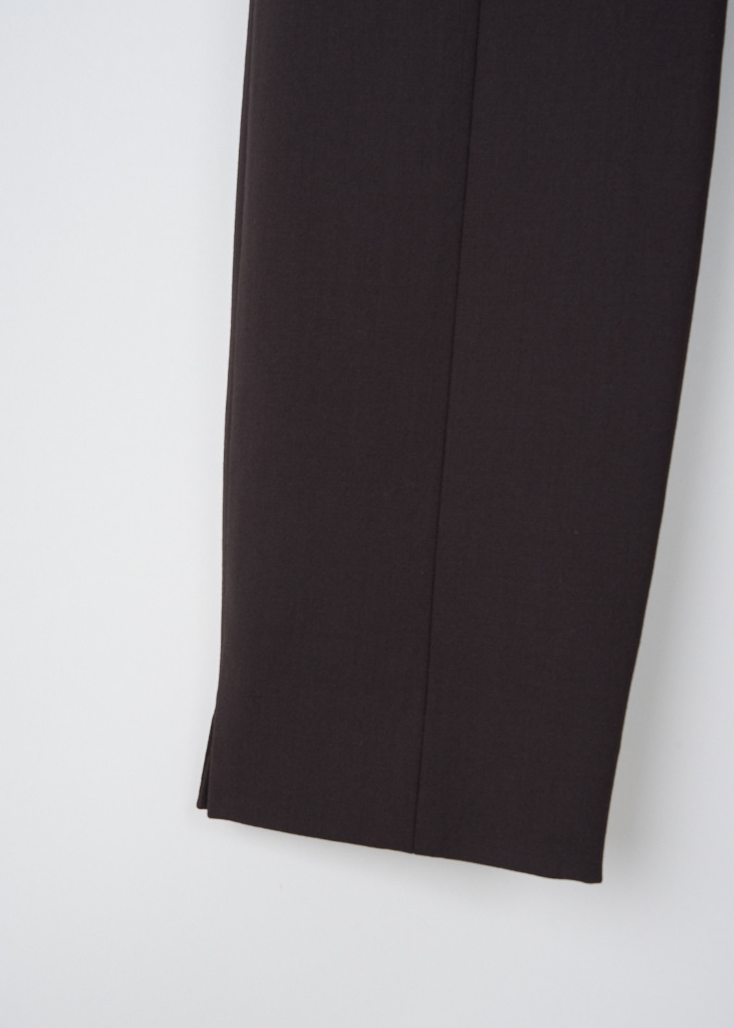 The Row, Sovino pants in Saddle Brown, SOVINO_PANT_5922W2119_SADDLE_BROWN, Brown, Detail, These Sovino pants in Saddle Brown have a narrow waistband with a side zip closure. These pants have skinny pant legs with pressed creases. The hem has small side slits. 