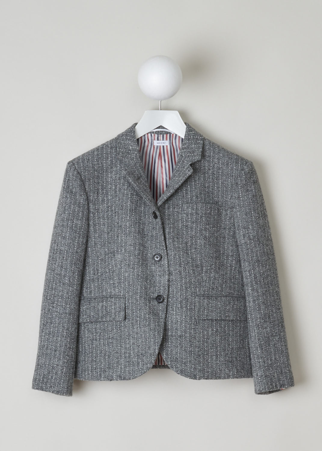 THOM BROWNE, GREY STRIPED TWEED BLAZER, FBC010V_06879_035_MED_GREY, Grey, Front, Grey tweed blazer with a horizontal stripe. This blazer features a notch lapel, a single chest pocket and two flap pockets and long cuffed sleeves with four buttons. Two buttons on the front are your fastening option on this blazer. This the back, the grosgrain tab can be found.
