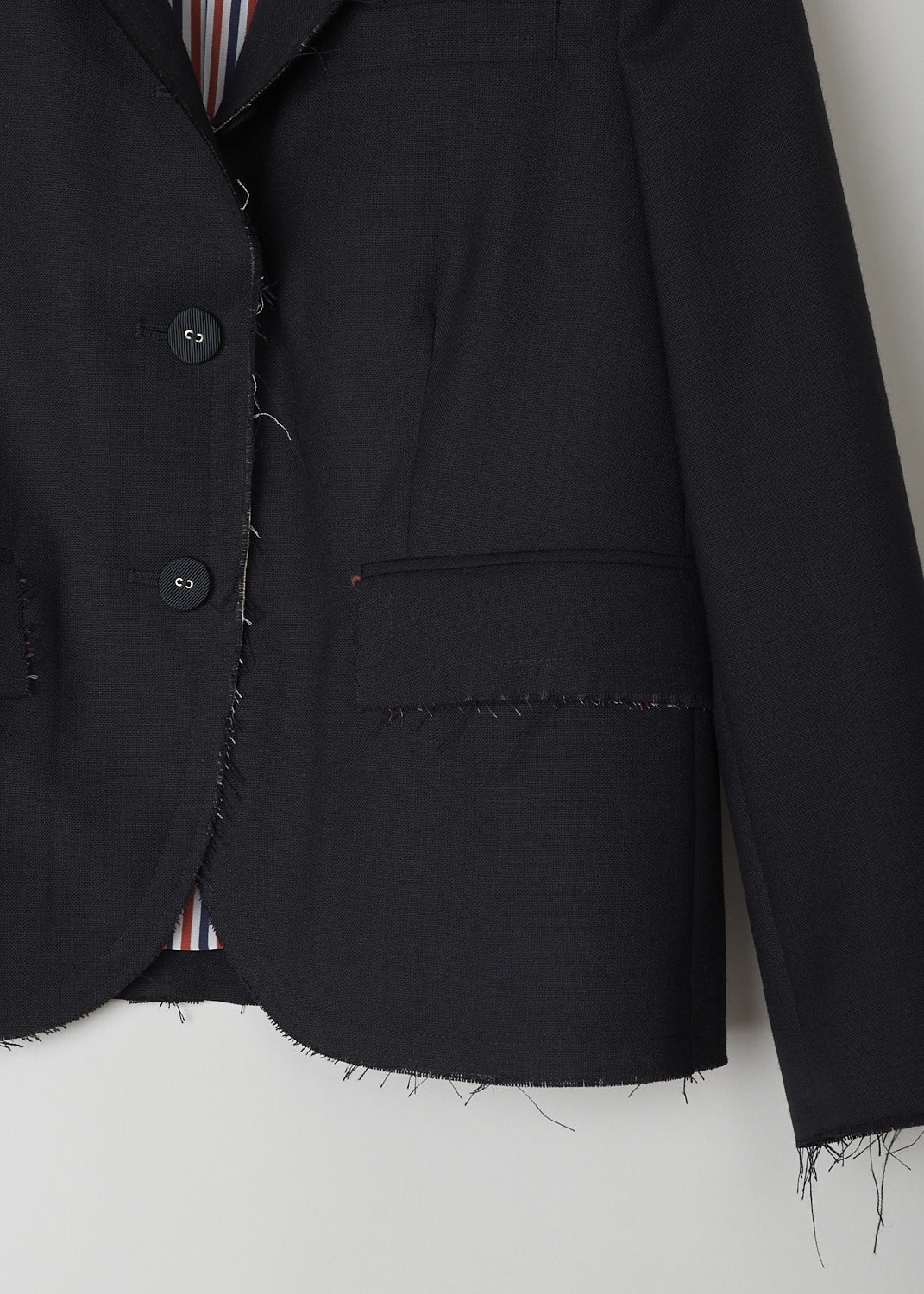 THOM BROWNE, BLACK BLAZER WITH EXPOSED SEAMS AND RAW EDGES, FBC608B_00473_001, Black, Detail 1, Black blazer featuring notch lapel and long cuffed sleeves with four buttons. In the front, a single chest pocket and two flap pockets can be found. What makes this model stand out most, are the raw edges throughout the blazer. Two buttons on the front are your fastening option on this blazer.

