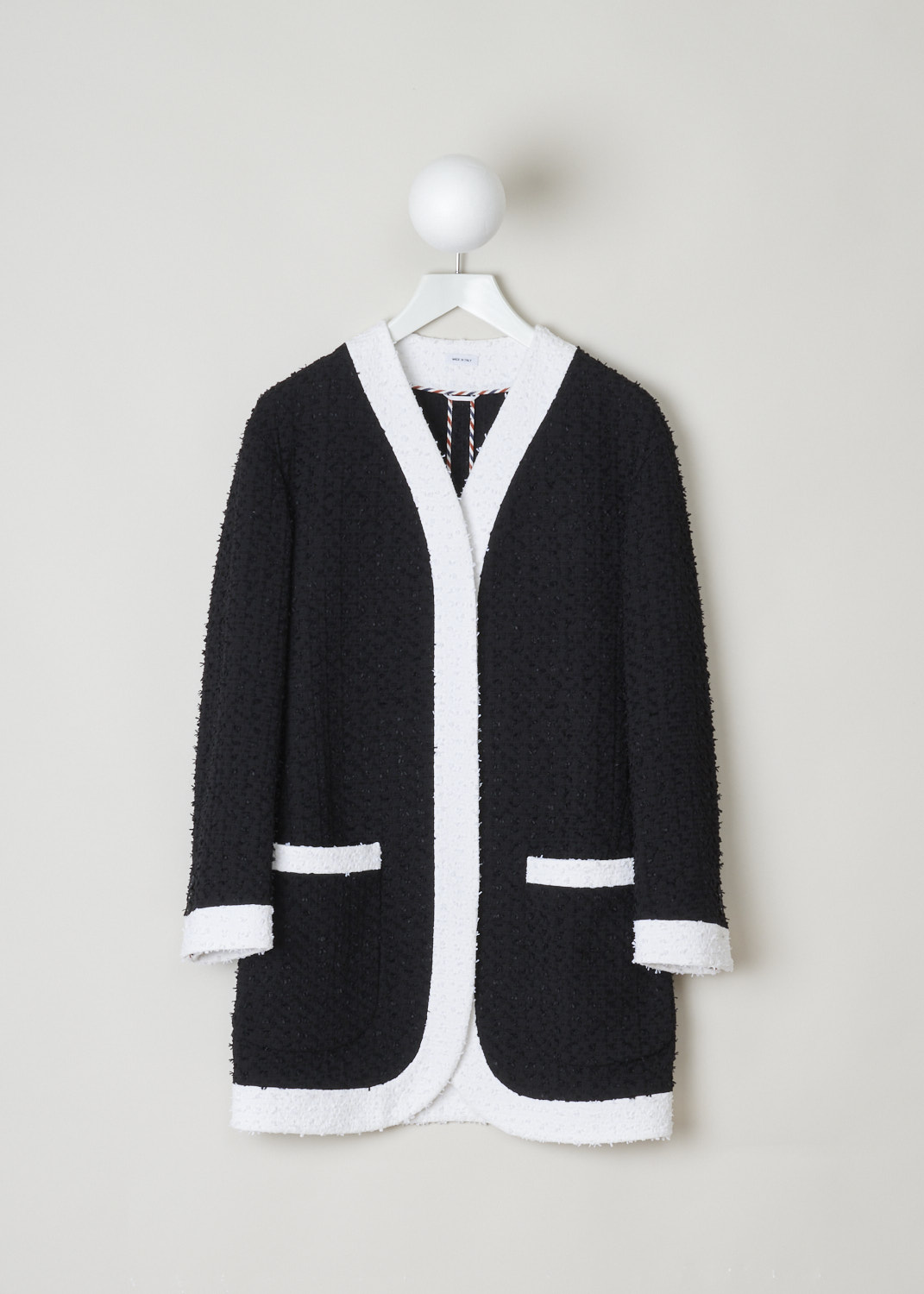 Thom Browne, Unconstructed menswear fit cardigan in solid eyelash yarn tweed, FBC679C_06751_001, Black, White, Front, Unconstructed black and white cardigan jacket made from solid eyelash yarn tweed. The jacket has a menswear fit with dropped shoulders. The buttons are concealed by the contrasting white trims. The cardigan has two pockets on the front, which are also adorned with contrasting trims.
