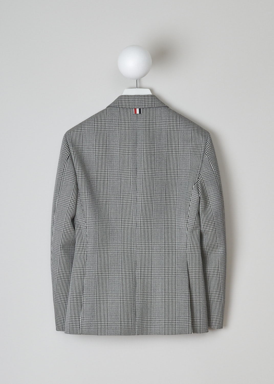 THOM BROWNE, BLACK AND WHITE PRINCE DE GALLES CHECK SPORT JACKET, FBC681A_06298_980, Black, White, Print, Back, This single-breasted sport jacket has a black-and-white prince de galles check motif. The jacket has a notched lapel, a front button closure and a nipped waist. The long sleeves have buttoned cuffs. In the front, the jacket has a single breast pocket and two flap welt pockets. On the inside, the jacket has a striped lining, three inner pockets and a name tag. The brand's signature grosgrain loop tab can be found in the back. The jacket has a double vent. 
  
