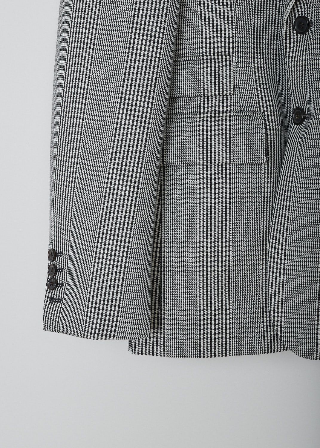 THOM BROWNE, BLACK AND WHITE PRINCE DE GALLES CHECK SPORT JACKET, FBC681A_06298_980, Black, White, Print, Detail, This single-breasted sport jacket has a black-and-white prince de galles check motif. The jacket has a notched lapel, a front button closure and a nipped waist. The long sleeves have buttoned cuffs. In the front, the jacket has a single breast pocket and two flap welt pockets. On the inside, the jacket has a striped lining, three inner pockets and a name tag. The brand's signature grosgrain loop tab can be found in the back. The jacket has a double vent. 
  
