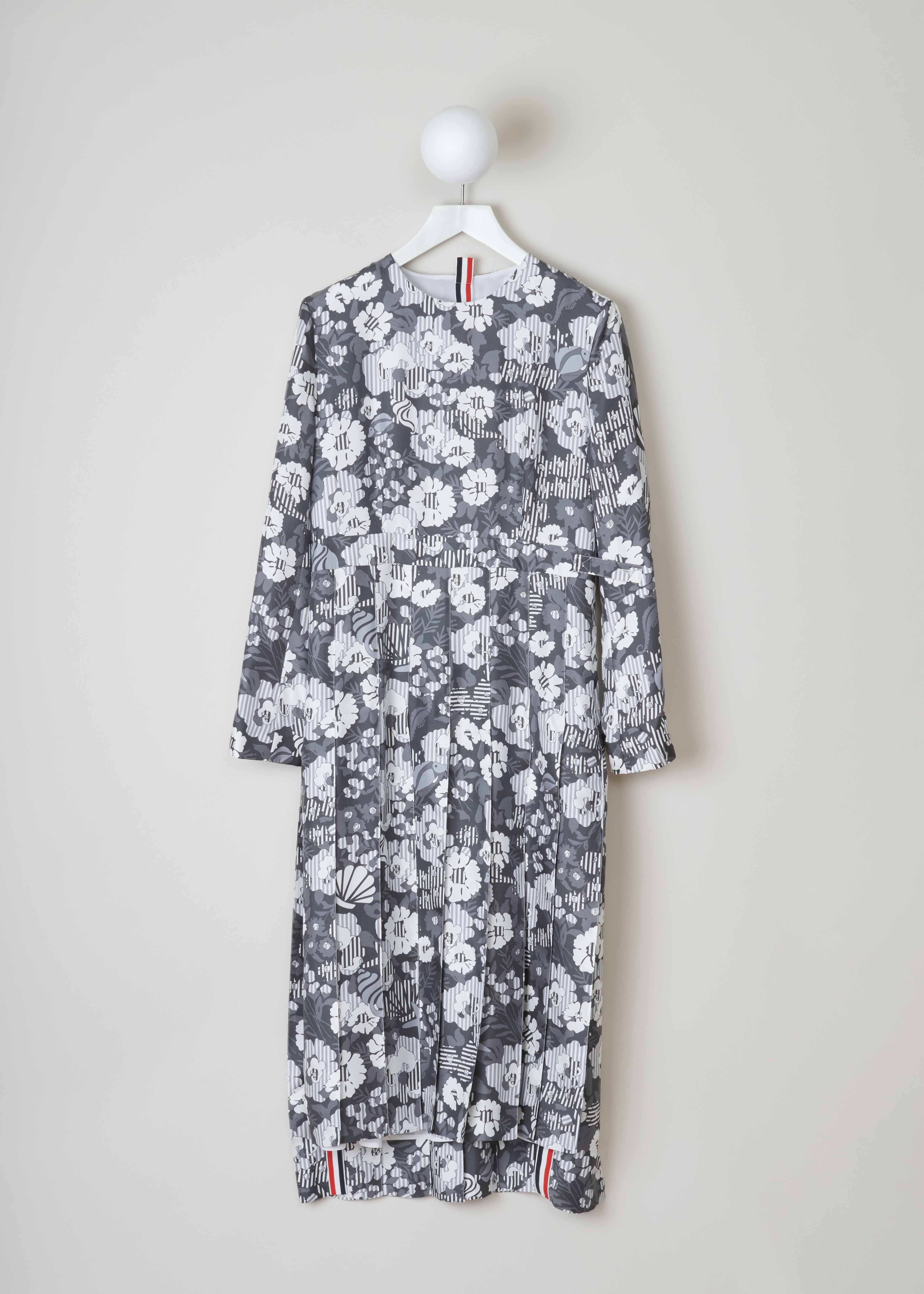 Thom Browne Sunny floral print pleated dress FSD30A_06160_035_Med_Grey front. Long sleeved silk dress in the sunny floral pattern with a round neckline, an adjustable waist, an over the knee pleated skirt and an invisible zipper fastening on the back.