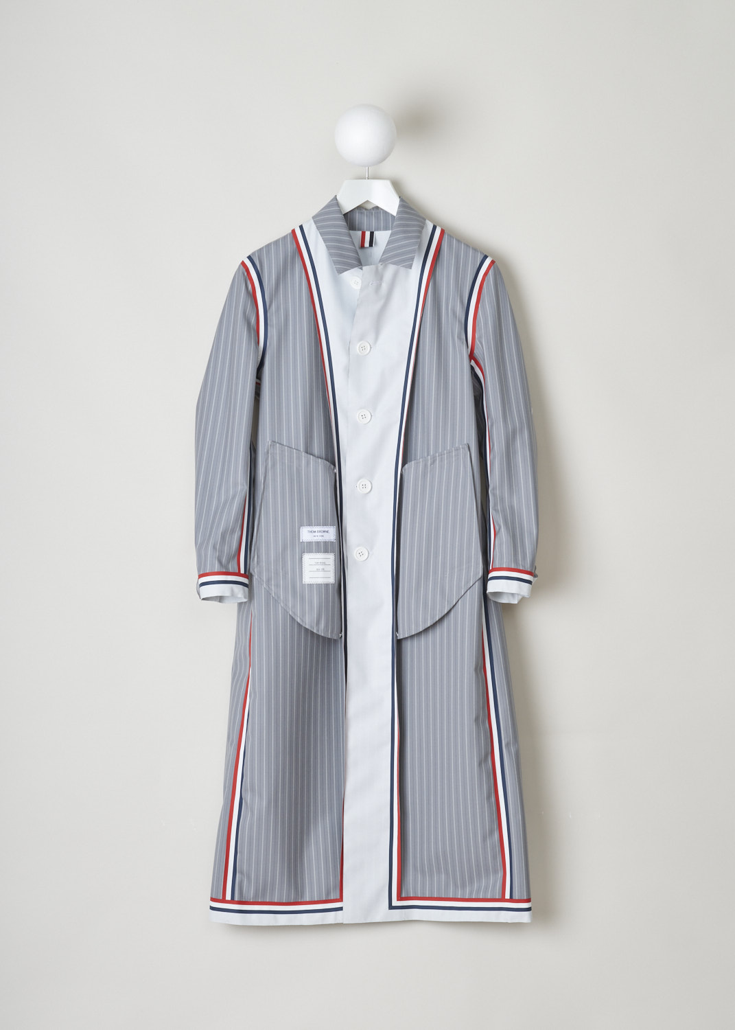 Thom Browne, Double sided water repellent overcoat, FOC454D_04358_035, grey, print, front, Light grey pinstripe on one side and a mid-grey pinstripe motif on the other. So basically you are getting 2 overcoats for the price of one. featuring a pointed collar, long cuffed sleeves with functional buttons. A fun little detail about the buttons are they are made of rubber so they feel a certain way and are a bit flexible.   