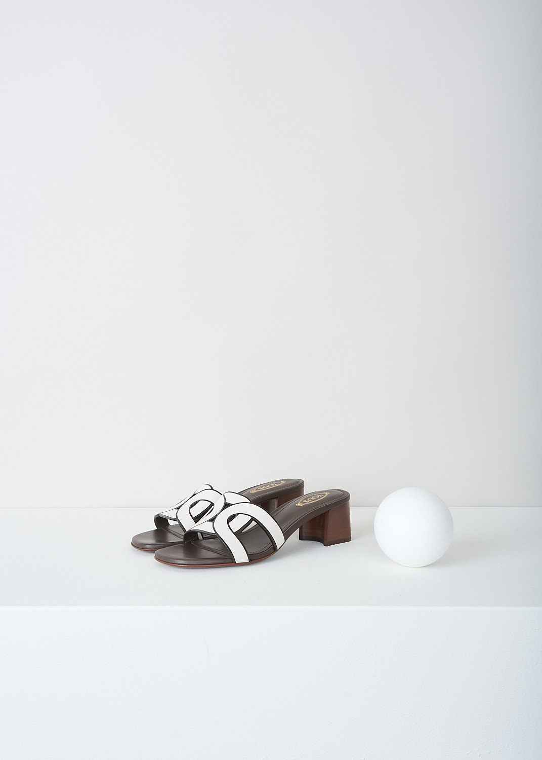 Tod's, Two-tone pumps with chain-like strap, XXW04J0GU70_MID_B001, White, Front, These slip-on pumps have a brown heel and sole and a contrasting white chain-like logo strap. These sandals have a squared open toe. 
