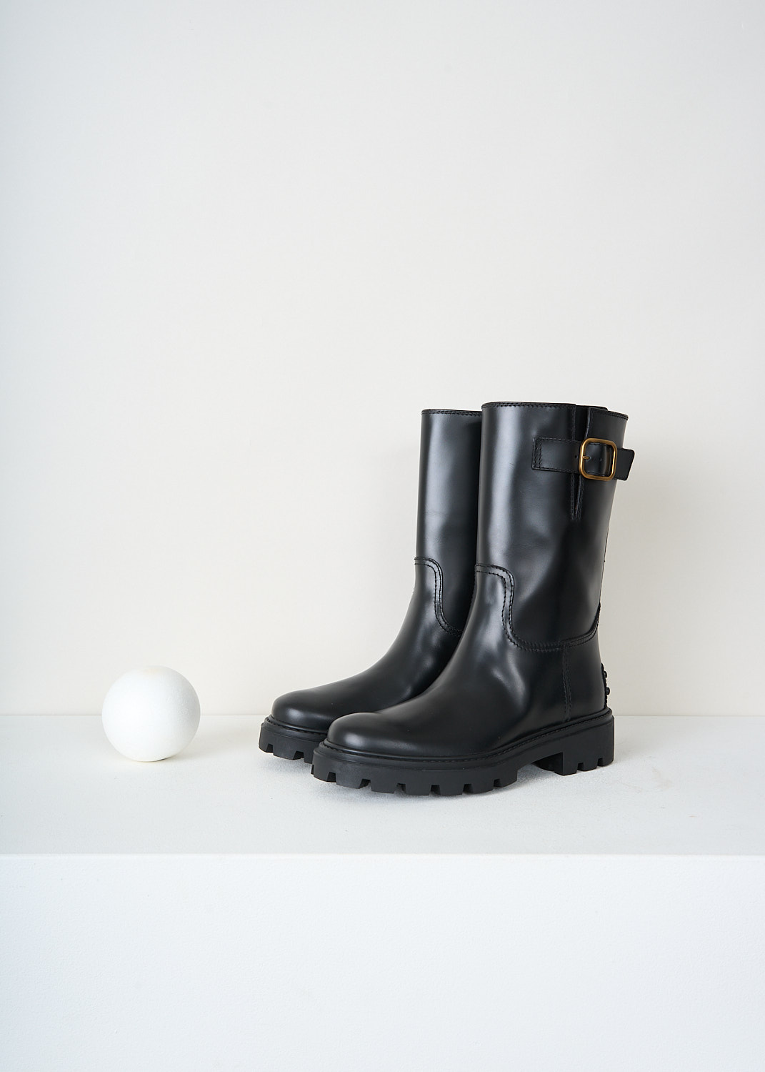 Front view of black Tod’s leather ankle boots featuring a rounded toe and sleek slip-on silhouette – designer sale item at Kiki’s Stocksale.