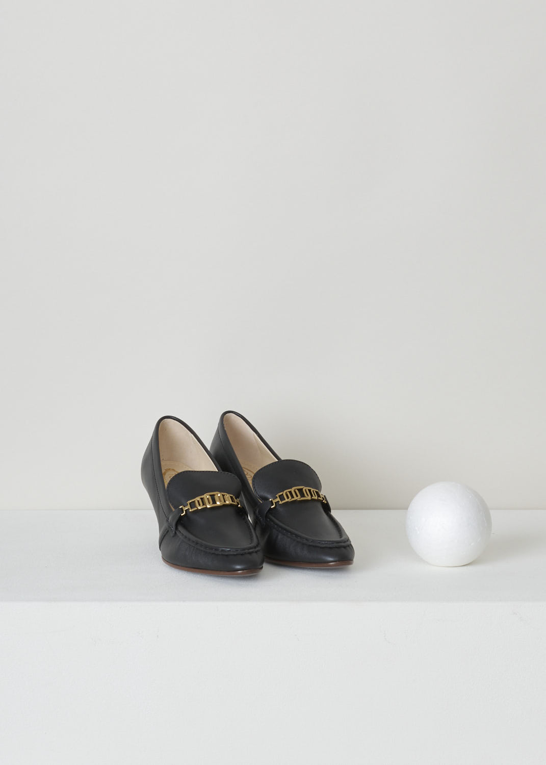 TODS, BLACK LEATHER LOAFERS WITH A TRAPEZOID HEEL, XXW09D0EC80_MID_B999_NERO, Black, Front, Black leather loafers with a wooden spool heel. This model has a pointed toe and a gold-tone buckle decorating the front. Around the trim, the leather is subtly pleated.
