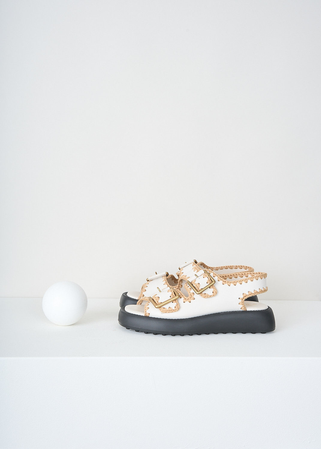 Tod's, White double-buckle sandals, XXW11K0GS80_MID_B015,  White, Side, These white leather sandals two straps with a gold-tone buckle. Crochet-fabric piping can be found throughout. These sandals have a black rubber sole with the brand's signature peddled profile.  

