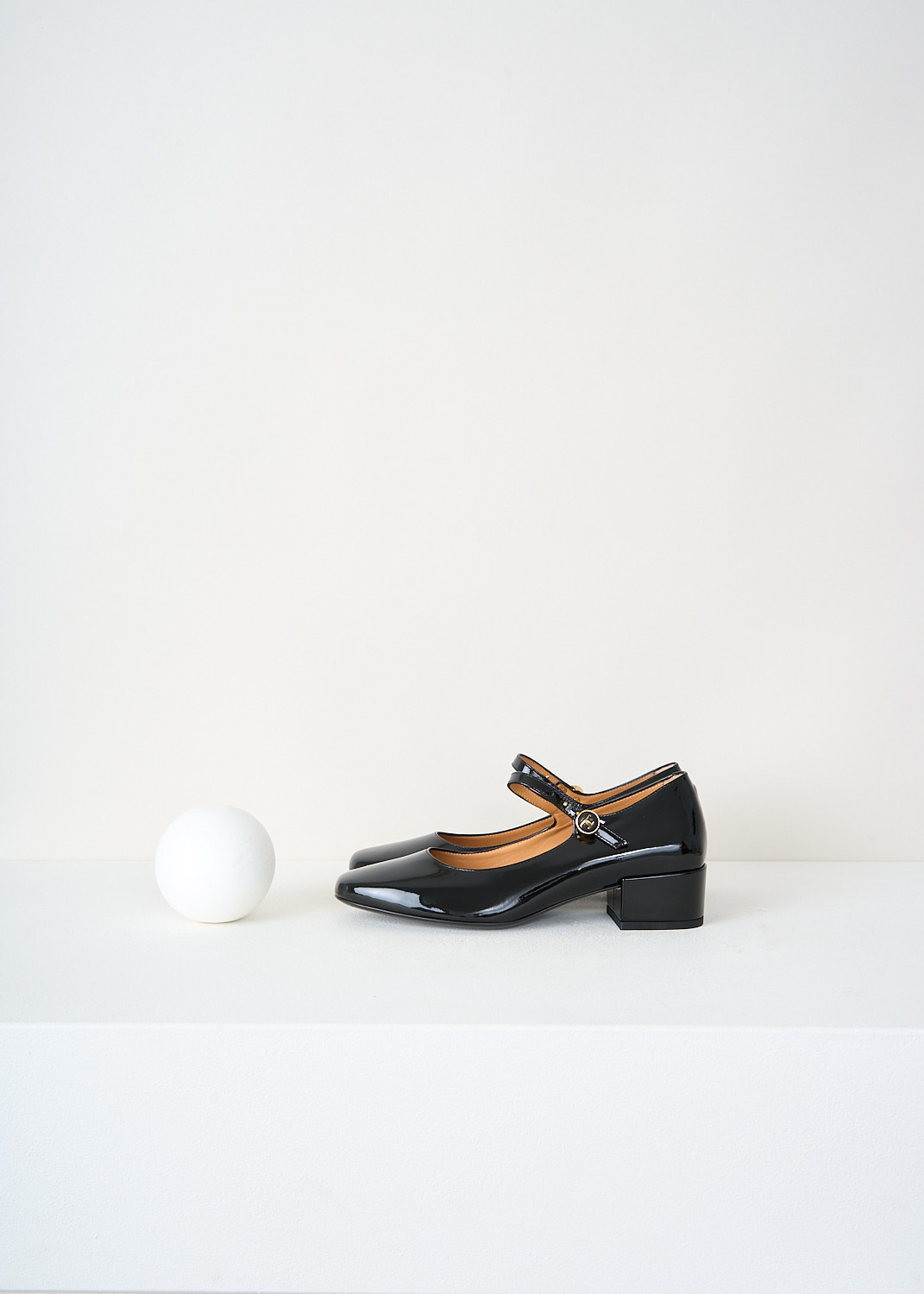 Tod’s black patent leather Mary Jane pumps with a rounded toe, low block heel and adjustable ankle strap – high-end designer footwear at Kiki’s Stocksale Maastricht.