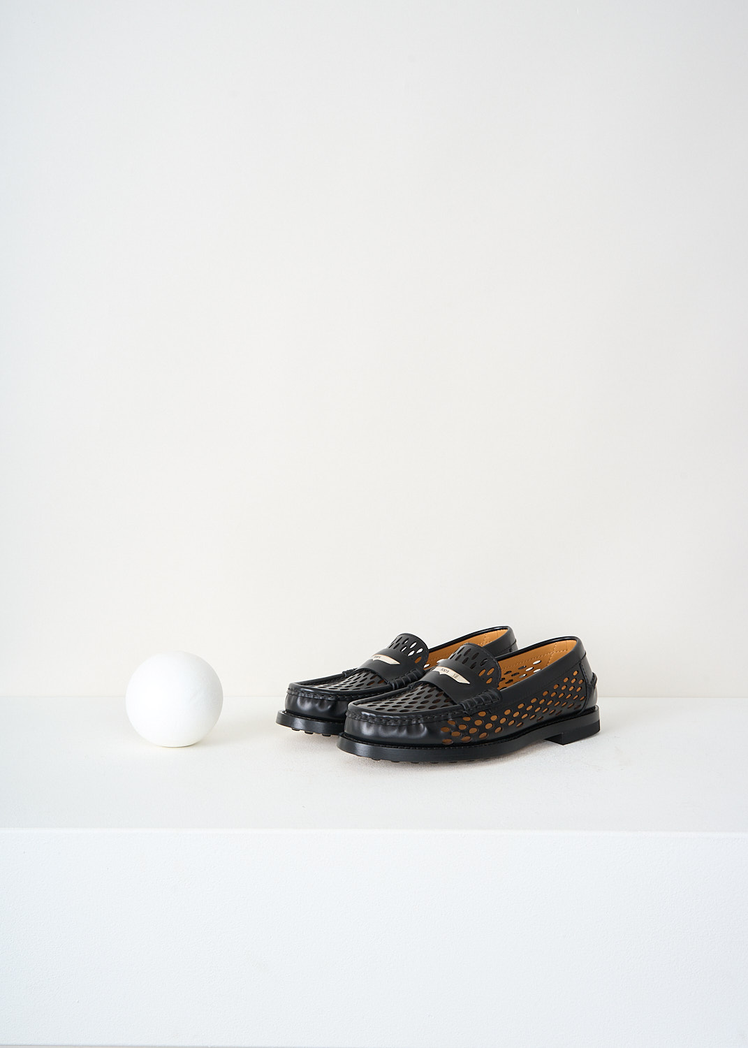 Front view of black Tod’s loafers featuring the signature penny loafer strap with a branded silver-tone detail – designer sale item at Kiki’s Stocksale.