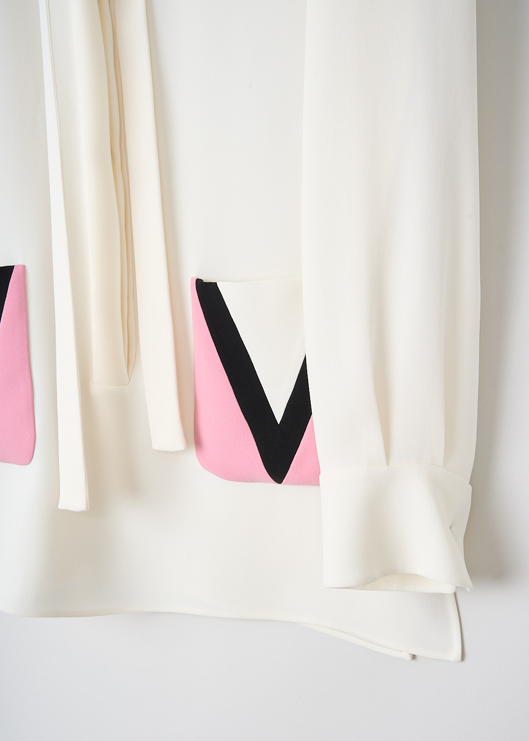 Valentino, White silk blouse with decorated pockets, 2B3AE7R21MM_6Z3, White, Pink, Detail, This white silk blouse has a classic collar with tie-detail. The blouse has a front button closure that doesn't reach the hem. The long sleeves have buttoned cuffs. In the front, the blouse has two pink patch pocket with the logo V on them in black. The blouse has a straight hemline with side slits. 
