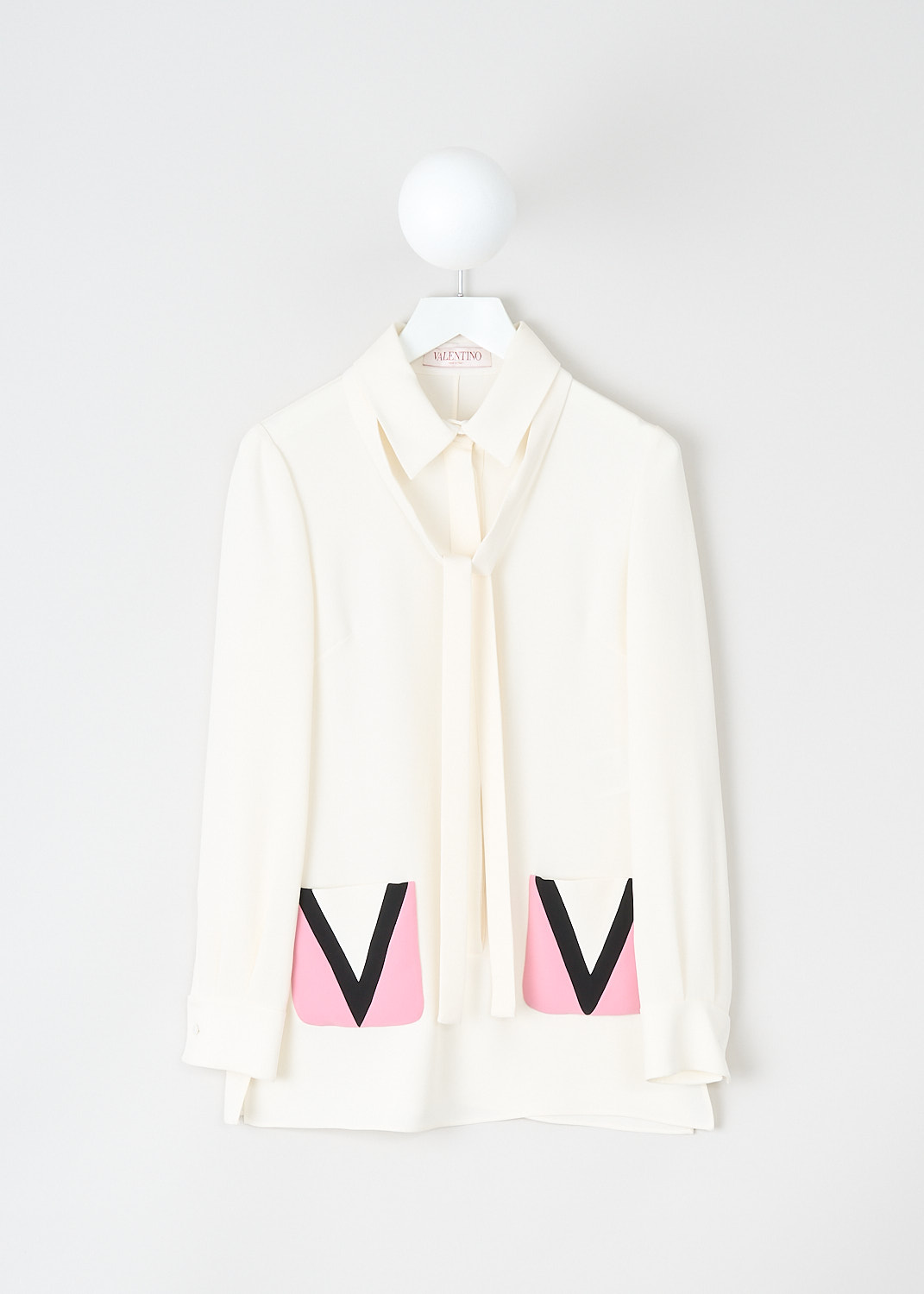 Valentino, White silk blouse with decorated pockets, 2B3AE7R21MM_6Z3, White, Pink, Front, This white silk blouse has a classic collar with tie-detail. The blouse has a front button closure that doesn't reach the hem. The long sleeves have buttoned cuffs. In the front, the blouse has two pink patch pocket with the logo V on them in black. The blouse has a straight hemline with side slits. 

