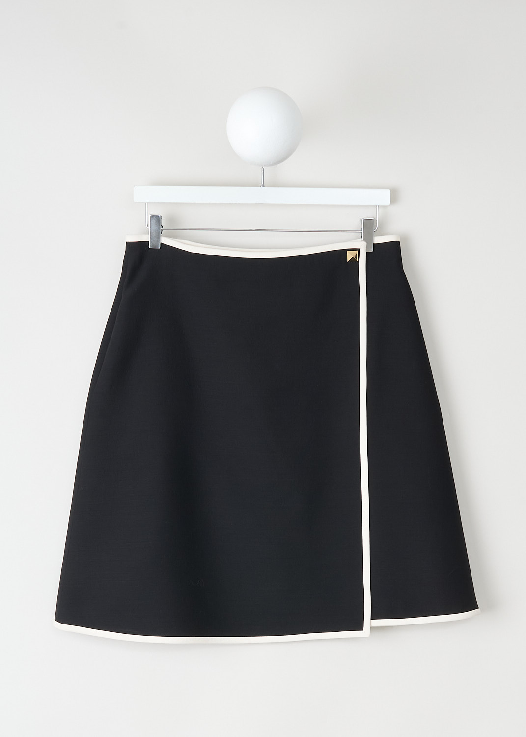 This skirt has a black high-waisted tailored fit with contrast trim, faux-wrap front detail and gold-tone stud closure, available at Kiki’s Stocksale Maastricht designer outlet.