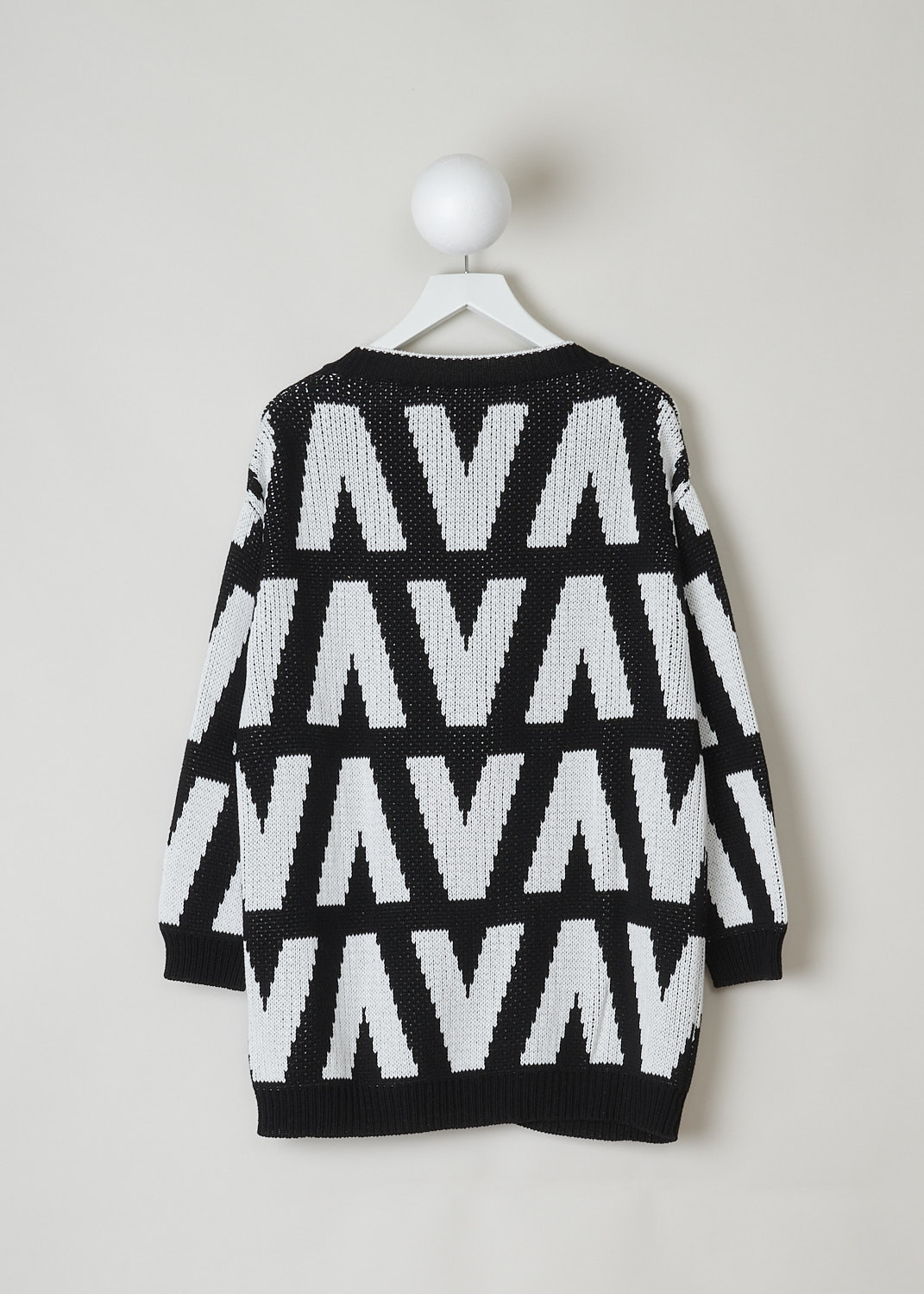 VALENTINO, BLACK AND WHITE CHUNKY KNIT CARDIGAN, WB3KA02I6G4_0NA, Black, White, Print, Back, This chunky knit cardigan has a black and white print with the brand's signature V incorporated in the motif. The cardigan has a ribbed V-neck. That same ribbed finish can be found along the front button closure, on the cuffs and on the hemline. Two patch pockets can be found on the front. The cardigan has an oversized silhouette. 

