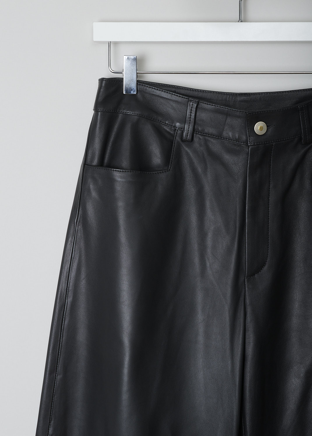 WANDLER, CHAMOMILE BLACK PANTS, 22306_060301_3200_CHAMOMILE_BLACK, Black, Detail, These black leather Chamomile pants have a waistband with belt loops and a button and zip closure. The pants have a high-waisted fit. The balloon legs are cropped at the ankle. These pants have slanted pockets in the front and patch pockets in the back. 

